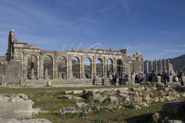 Image du Maroc Professionnelle de  L'après-midi, le soleil brille sur les arches de la basilique, le principal bâtiment administratif de l'ancienne ville romaine de Volubilis l'un des sites les mieux préservés au Maroc et le plus visité. La cité romaine se situe à proximité de Moulay Idriss Zerhoun à une trentaine de km au nord-ouest de Meknès, photo prise le jeudi 8 Mars 2012. Volubilis ville antique berbère Walili (Lauriers rose) qui date du 3e siècle avant J.-C. capitale du royaume de Maurétanie fondé comme seconde capital sous le règne de Juba II. (Photo / Abdeljalil Bounhar)
 